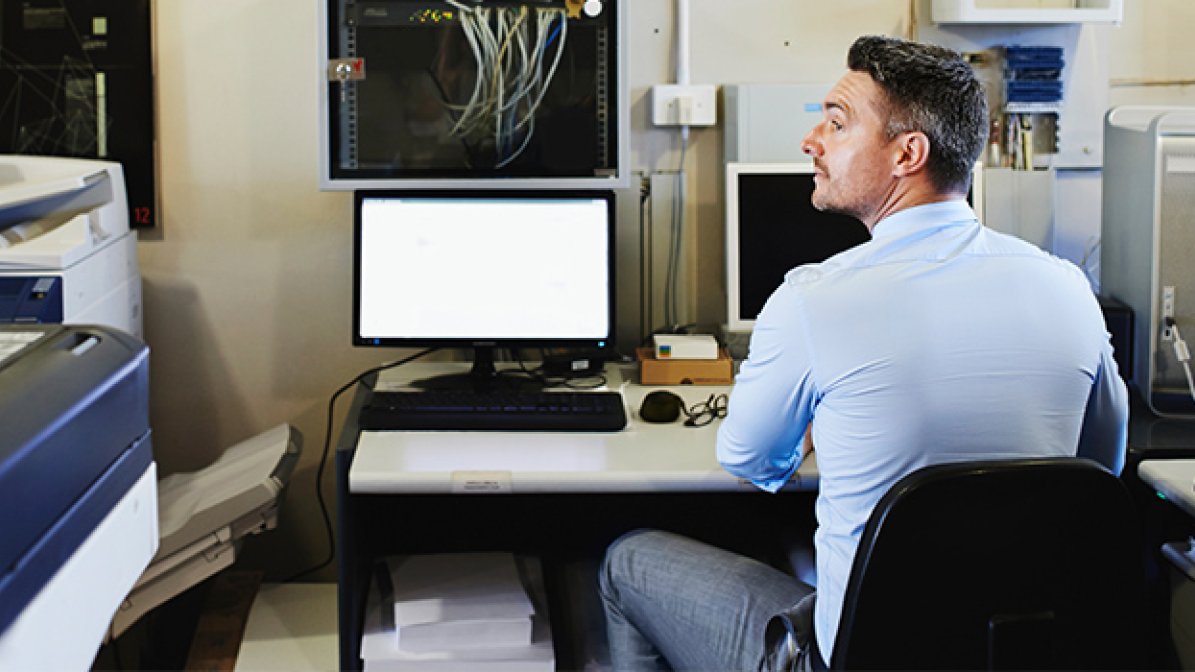 Man sitting at a desk, using a computer