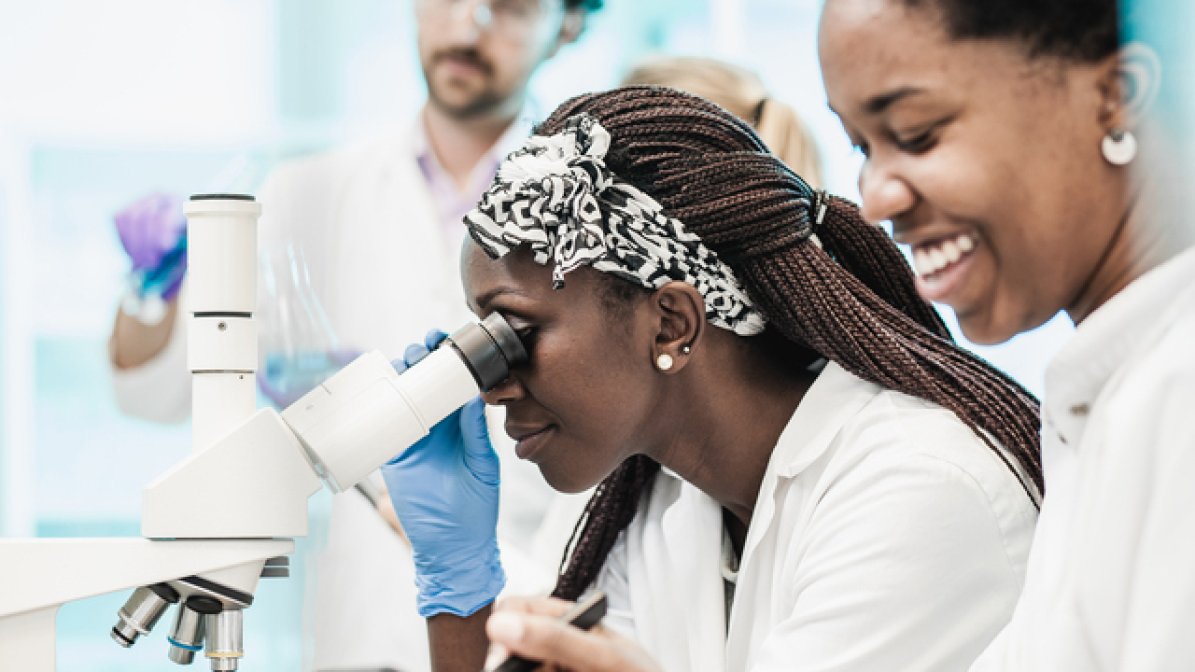 Toxicologist using microscope in lab