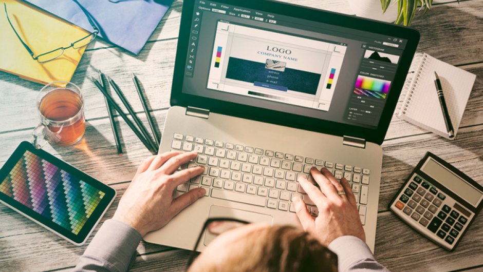 Creative apprentice at desk working on laptop 