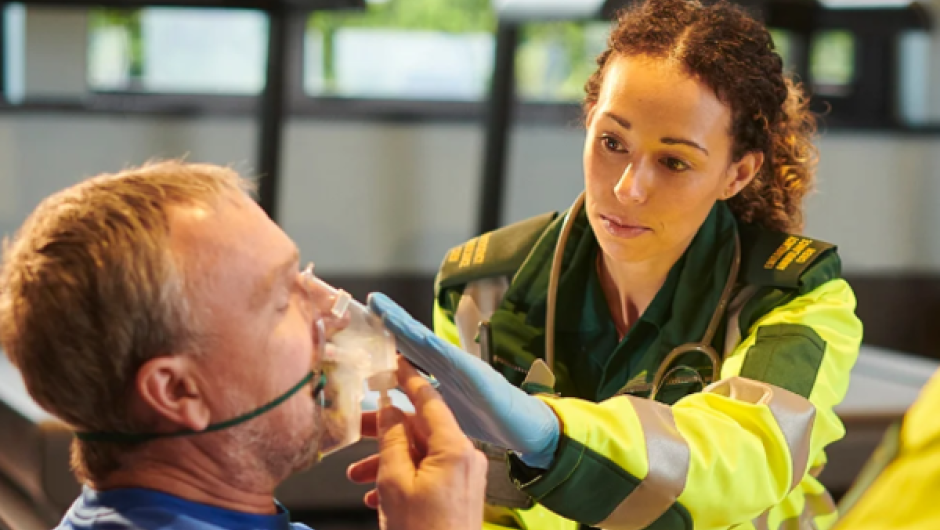 Paramedic giving oxygen to patient