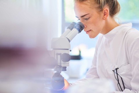 Woman looking through microscope 