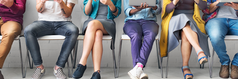 People sitting on chairs looking at tablets